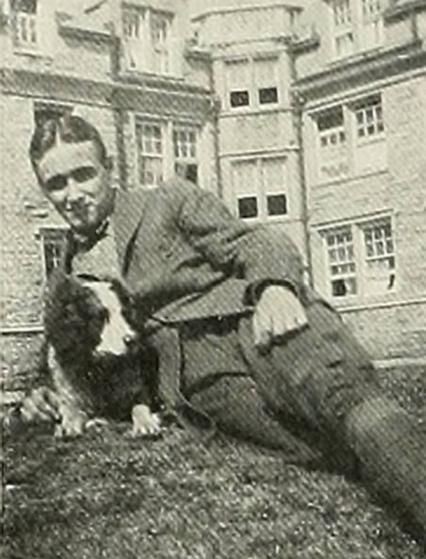 Pip Pollard with Dog Laying on Ground