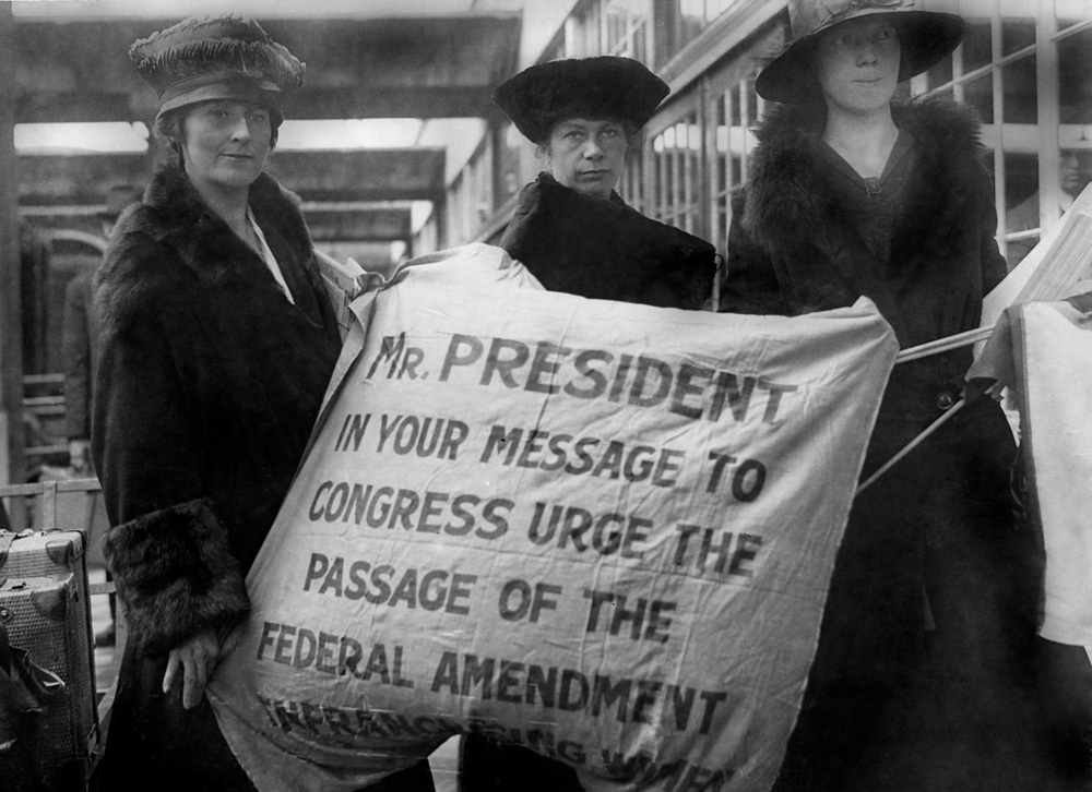 Amelia Himes Walker and two other women posing with a sign