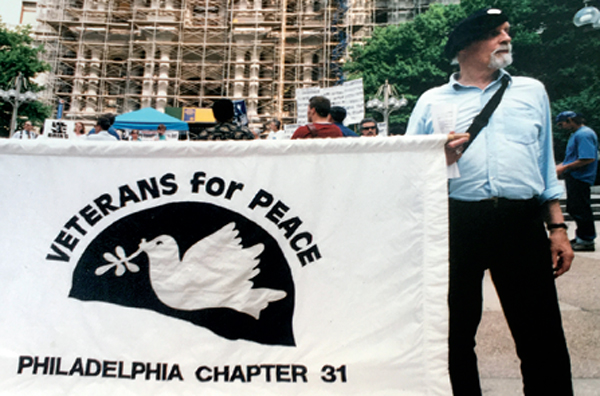Thompson Bradley wearing beret and supporting a banner reading "Veterans for Peace"