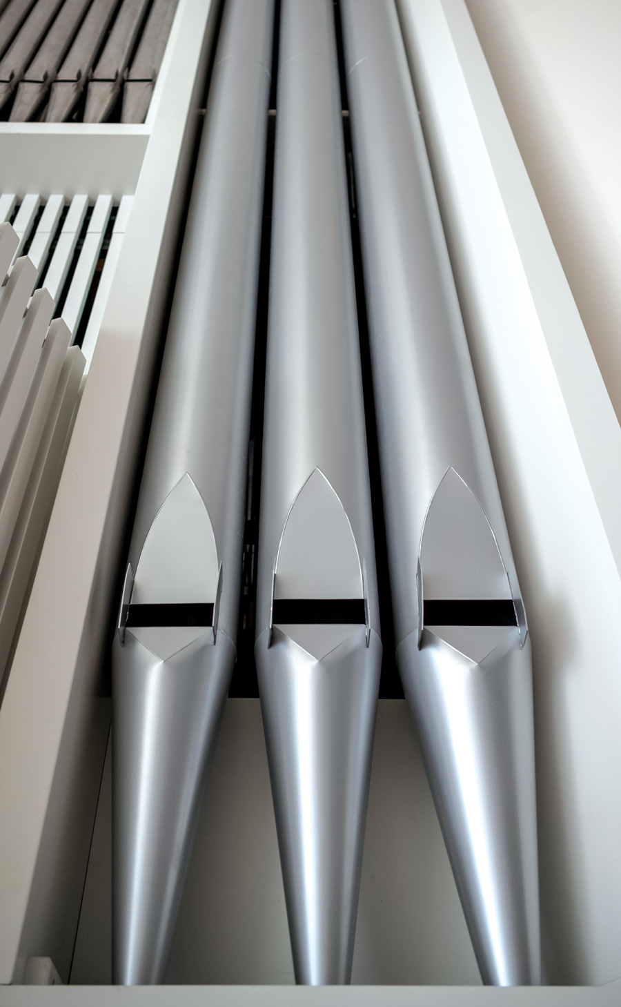 A closeup of three silver organ pipes.