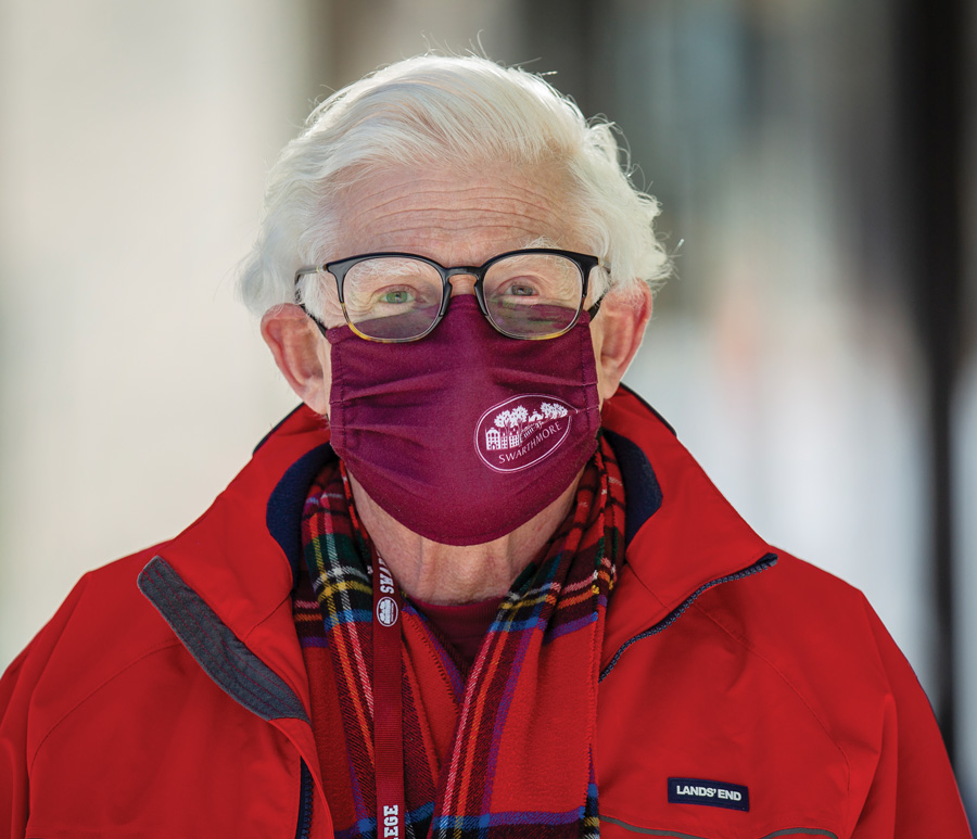 Mark Kuperberg, wearing a red coat, a red plaid scarf, and a garnet Swarthmore mask.