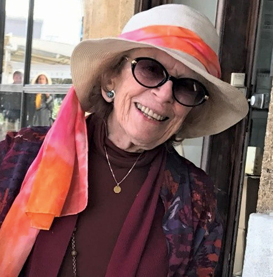 Mary Rowe wearing sunglasses and a white brimmed hat with a pink scarf wrapped around it
