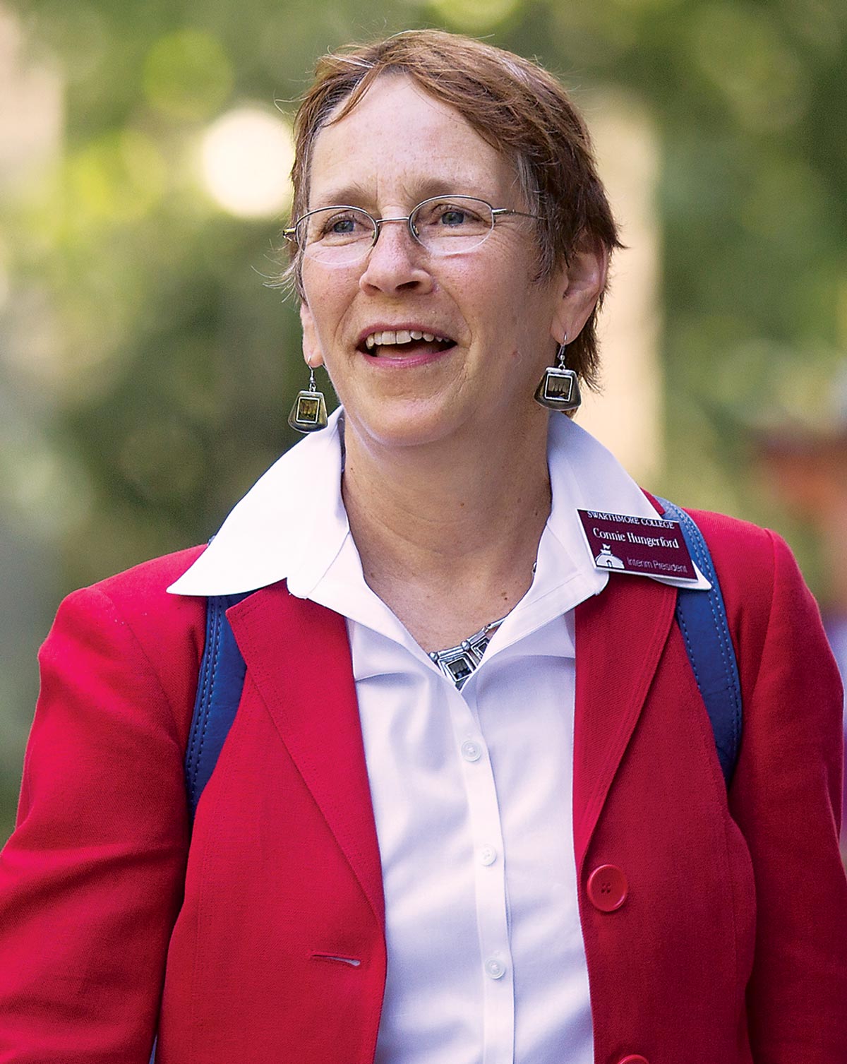 Connie Hungerford, smiling and wearing a red blazer and white collared shirt