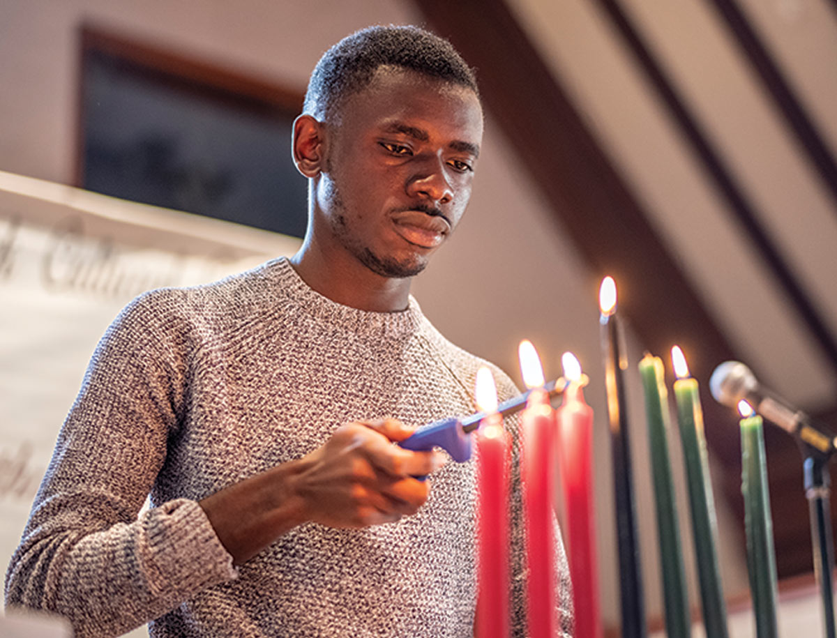 A Black student lighting Kwanzaa candles