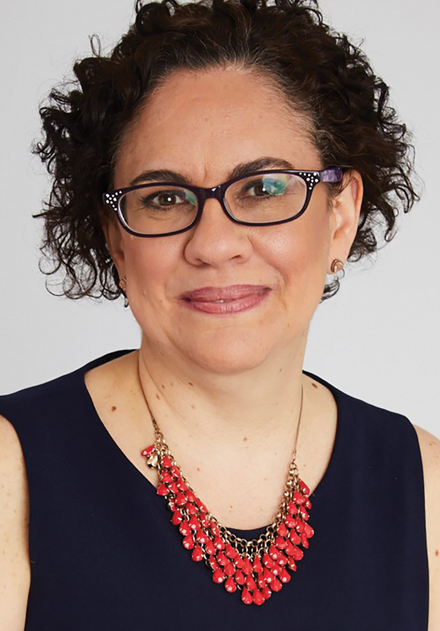 Headshot of Lourdes Rosado, wearing glasses and a red beaded necklace