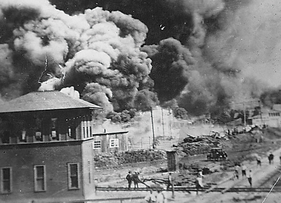 Archival photo from the massacre, showing smoke billowing out of a building