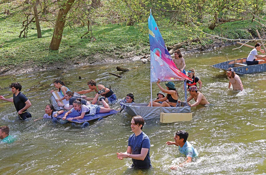 Young people gather in a creek with boat