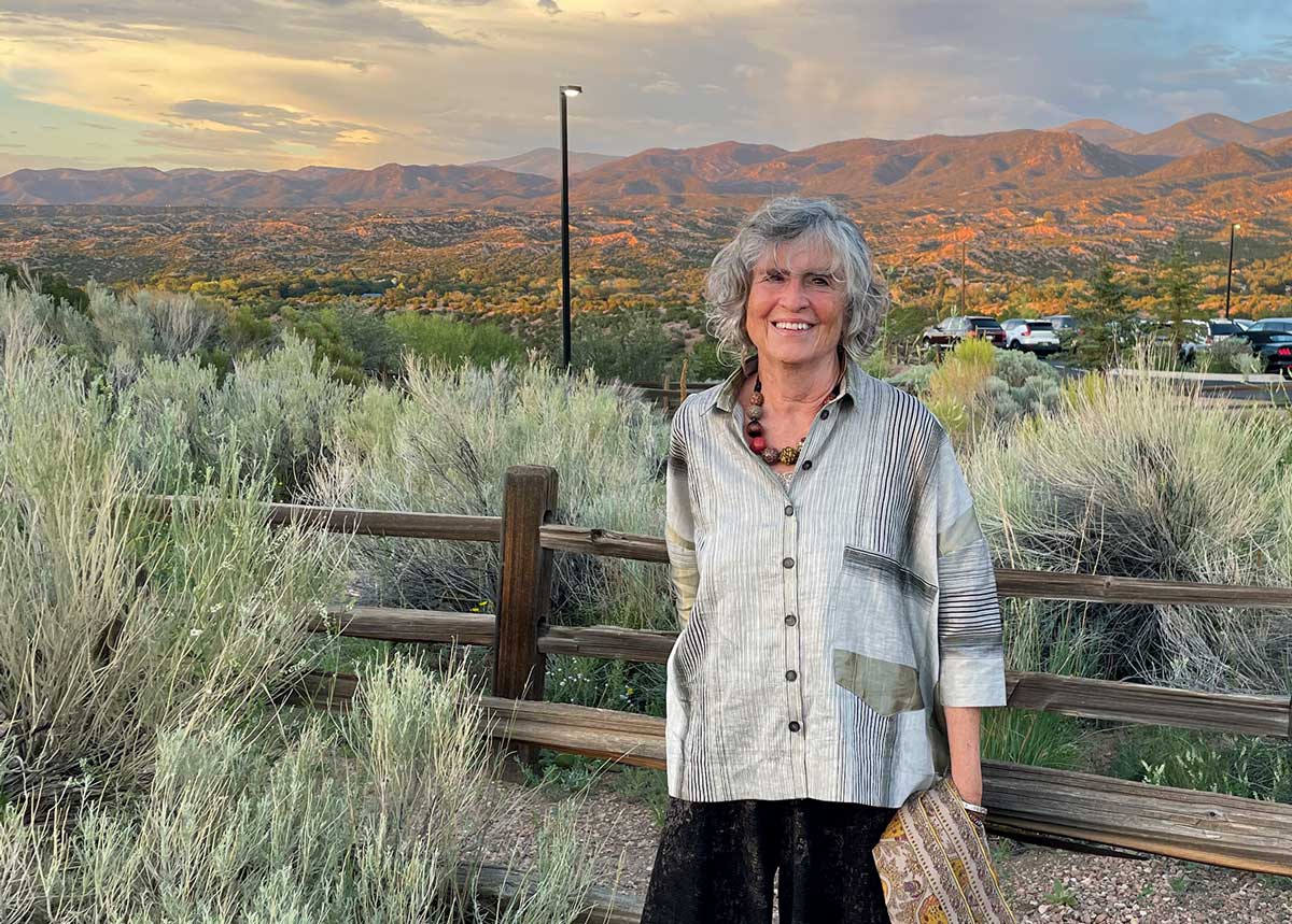Helene Silverblatt stands in front of the New Mexico mountains at sunset.