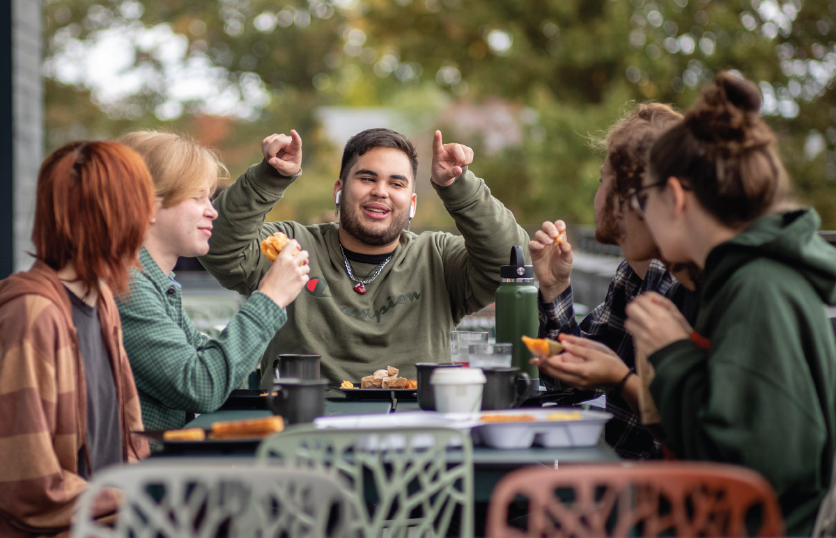 Students chat and dine outdoors.