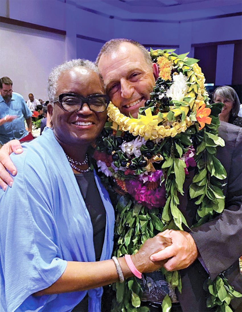 President Valerie Smith and Josh Green. Josh is wearing several flower leis after winning the election.