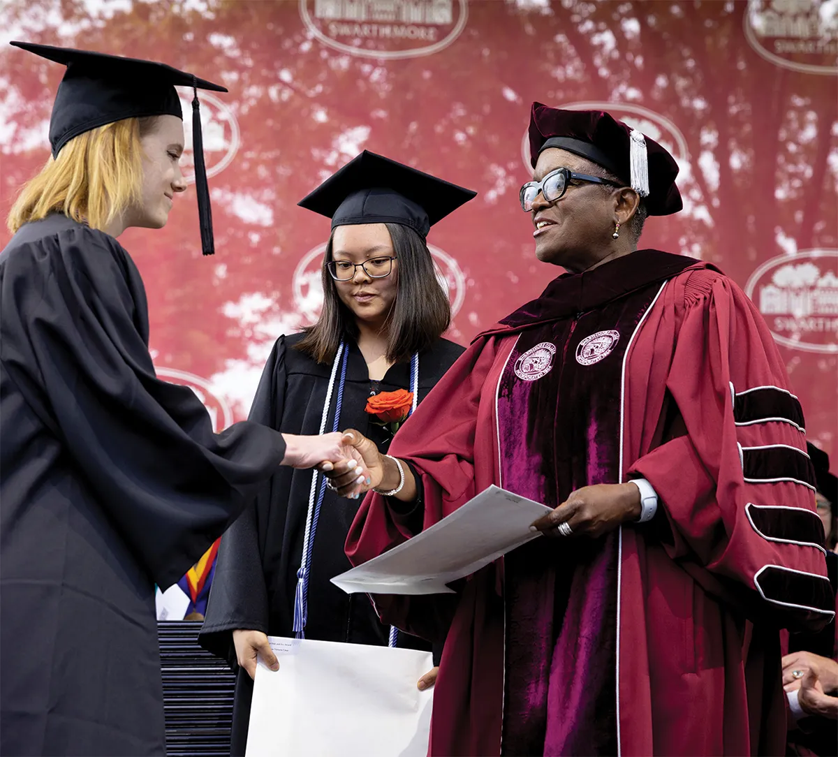 President Valerie Smith shakes hand with new graduate