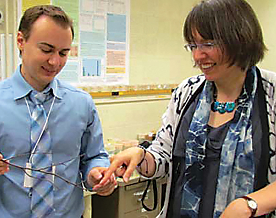 Medium close-up of professor and student handling spiders.