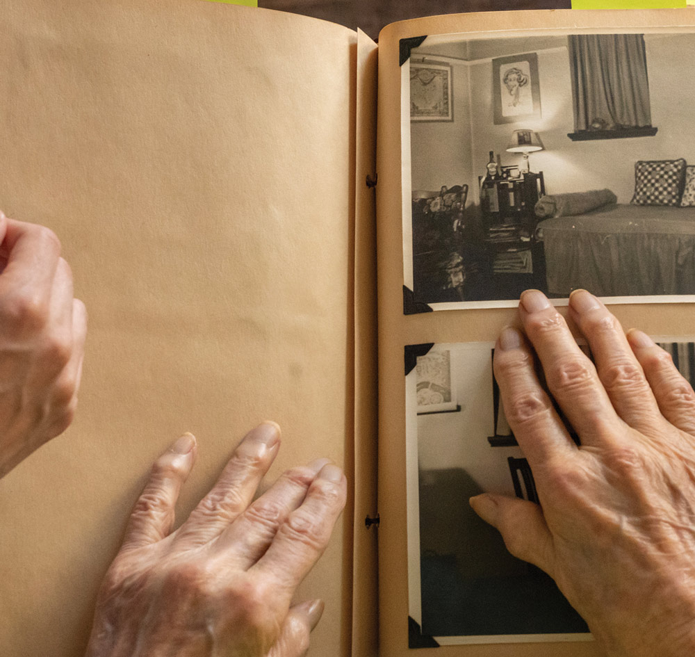 Lucy's hand on a photo album, open to a sepia-tone photo of her Swarthmore dorm