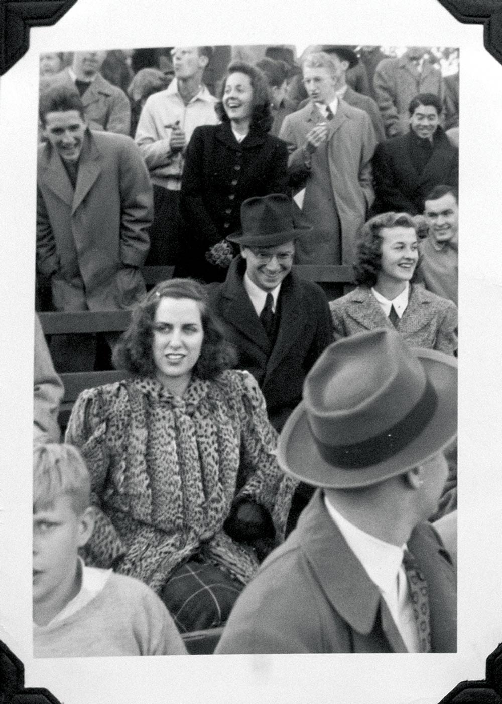 Lucy watching a football game, surrounded by fans in the stands