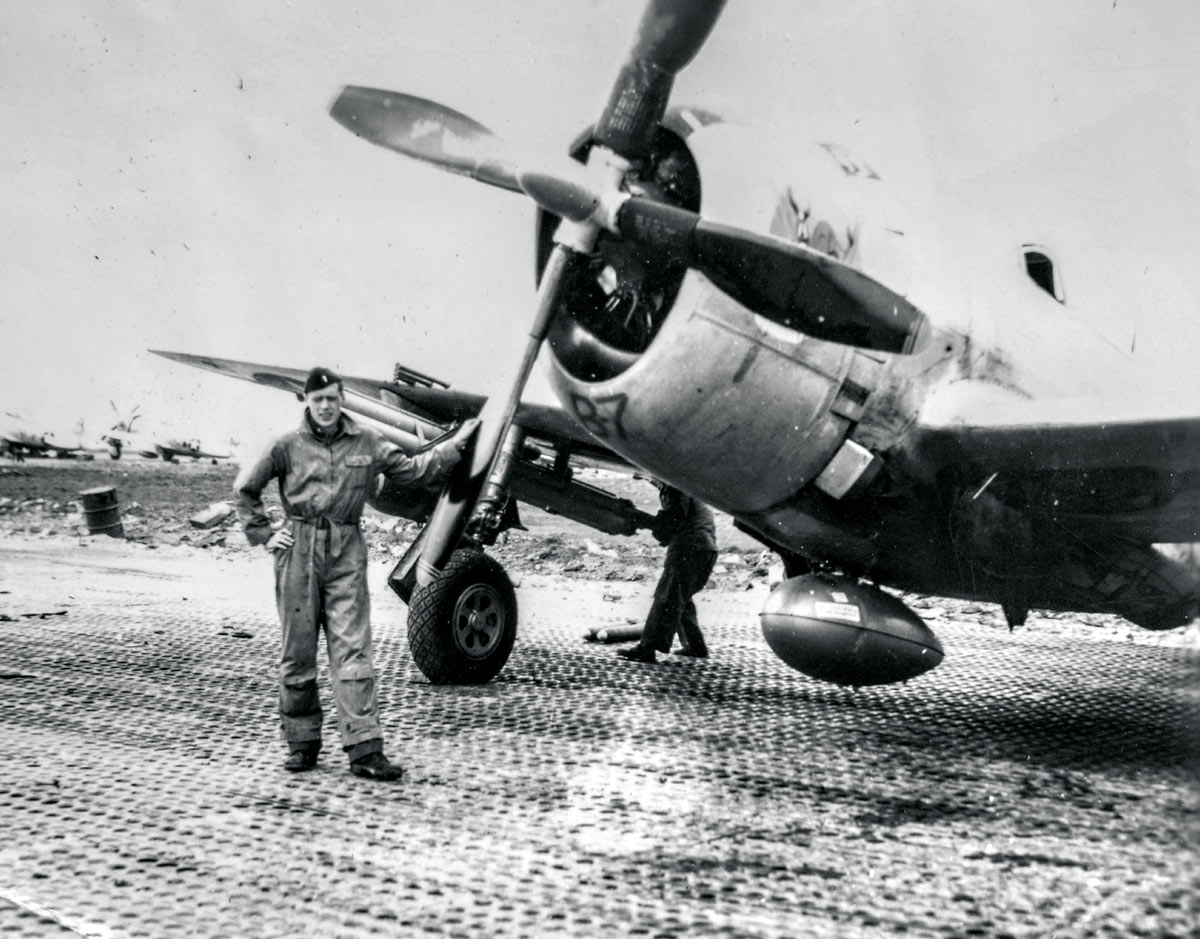 John, in his Army Air Corp uniform, stands next to his plane.