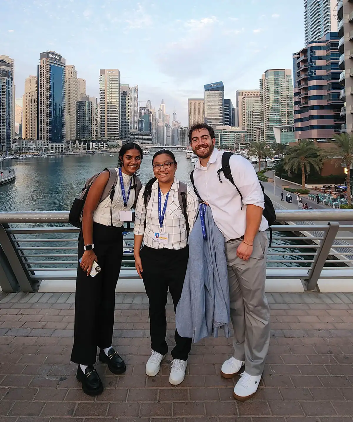 Students attendees of climate conference in Dubai pose on a bridge for a photo.