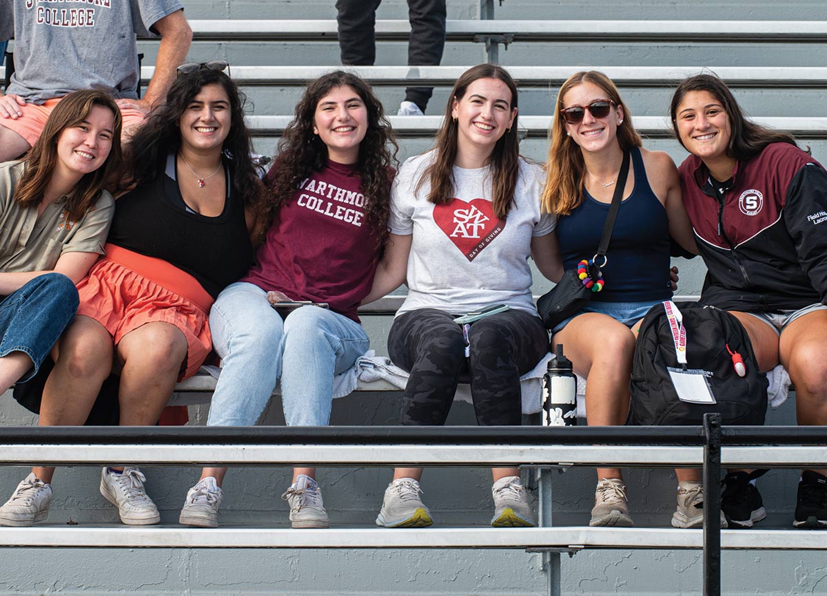 Smiling students pose in the bleachers for a group photo.