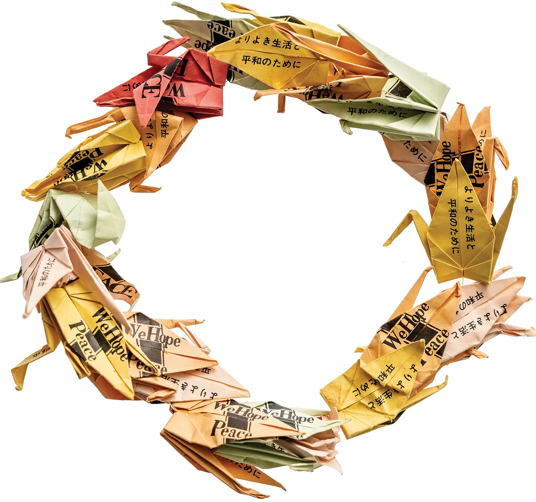 A faded wreath of multicolor paper cranes that say “We hope for peace” in English, and “for peace” and “for better life” in Japanese.
