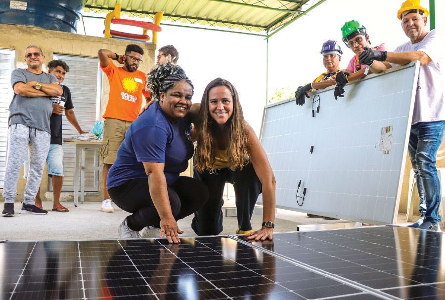 Theresa Williamson and Nill Santos install solar panels in Brazil.