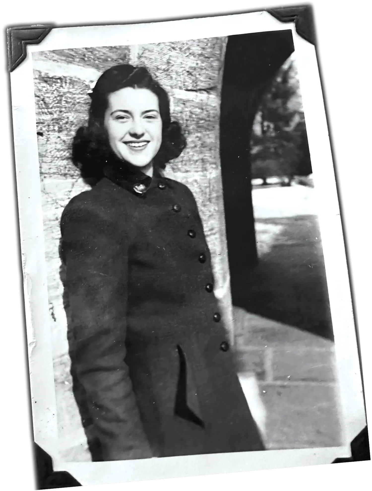 Black and white photo of Janice Rabb Anderson on campus, probably taken in the early 1940s. She wears a collared coat with seven buttons down the front.