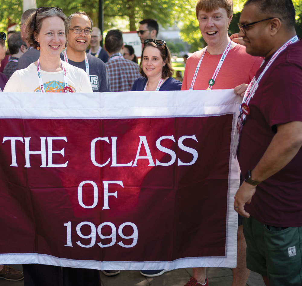Alums hold a the "Class of 1999" banner during the Parade of Classes.