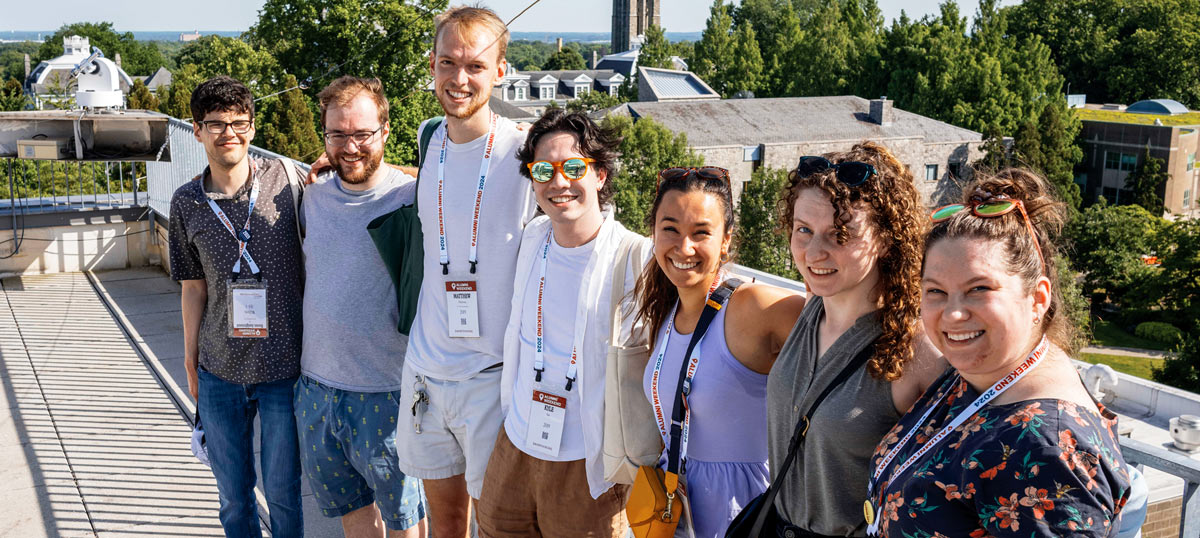 Alums pose together on a rooftop.
