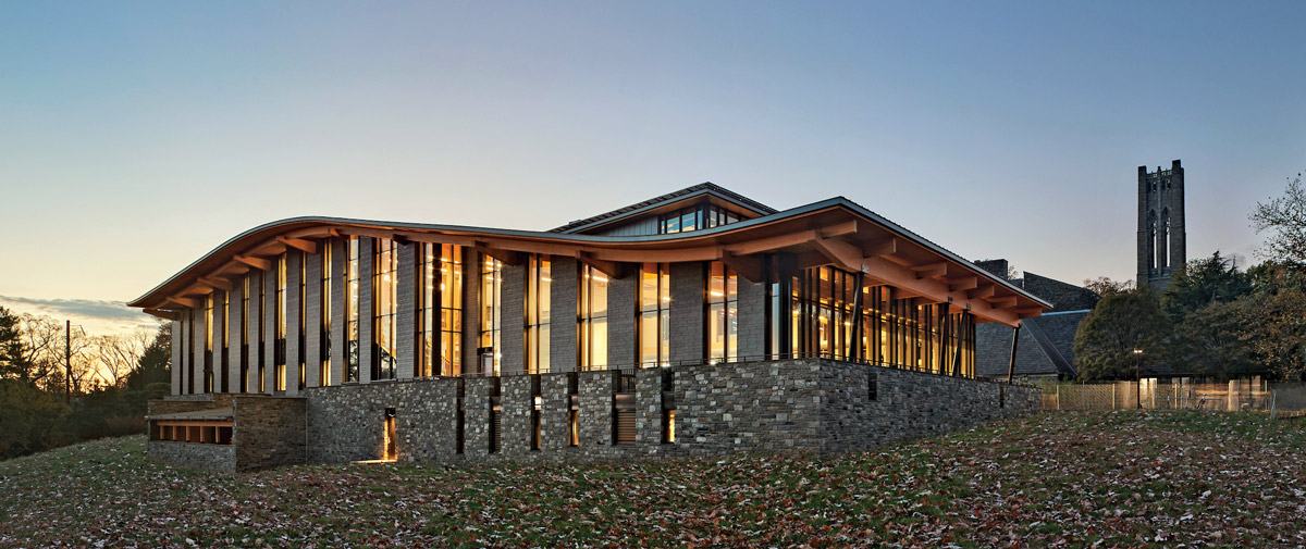 Light shines through the Dining Center windows as the sun sets behind it.