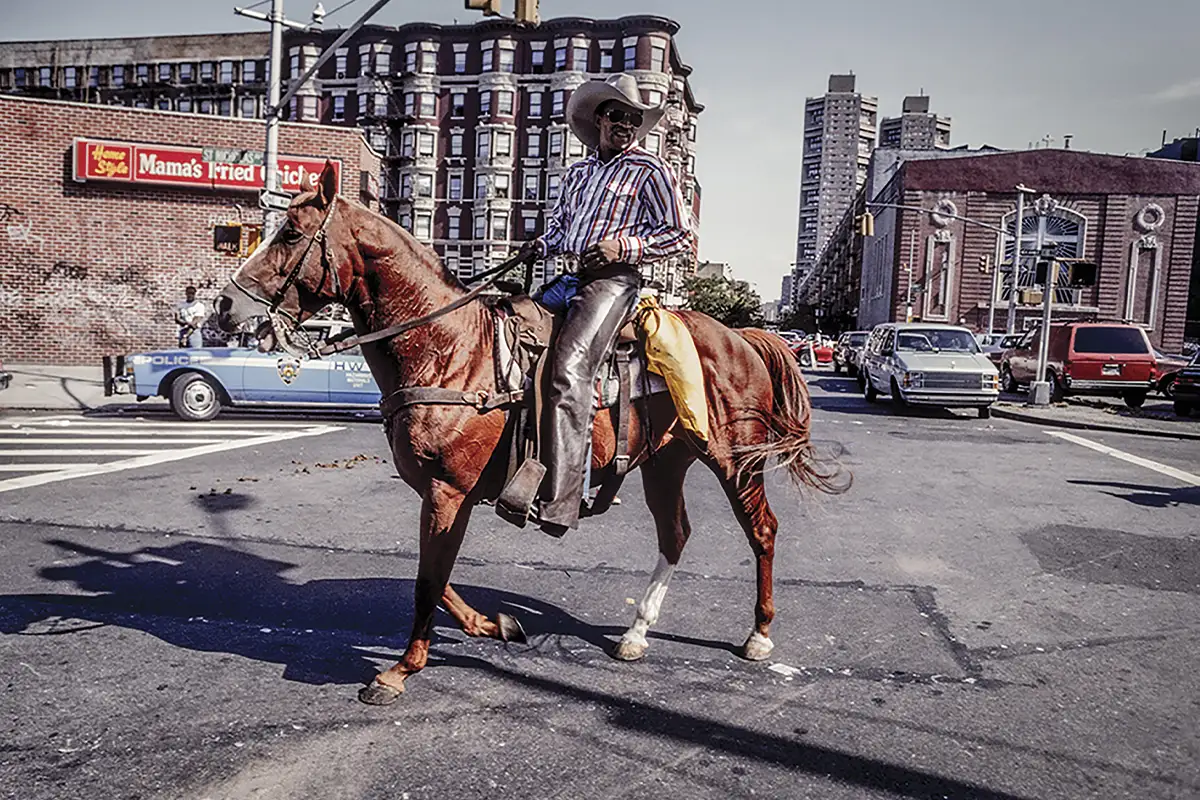 A man riding a horse passes through a New York intersection.