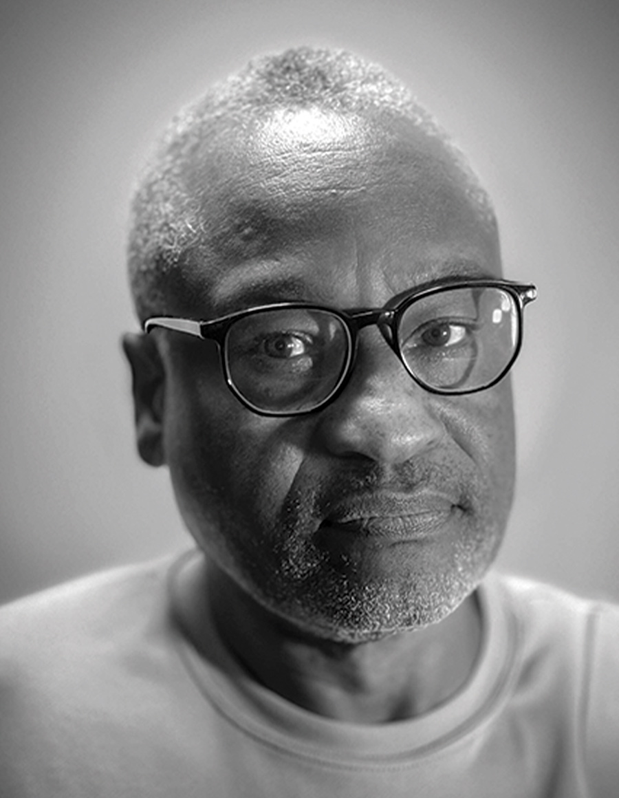 Black and white head shot of Ron Tarver, who wears glasses.