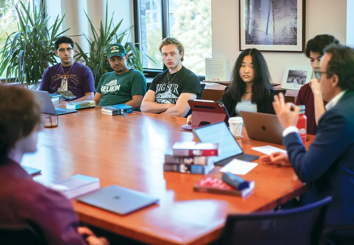 Students in the Borges class sit around a table with the professor at the head of it.