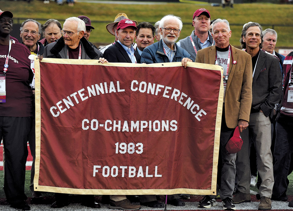 Former Swarthmore football players hold a banner that reads “Centennial Conference Co-Champions 1983 Football.”