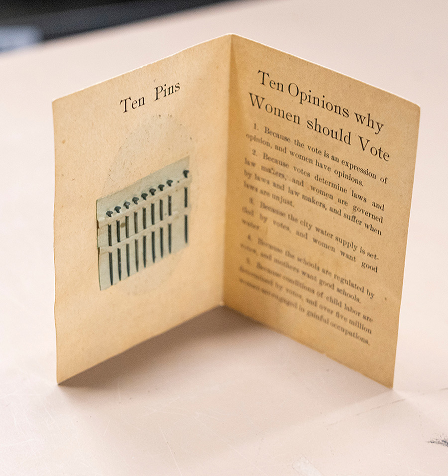 A pamphlet featuring 10 pins and a list of 10 reasons why women should vote.