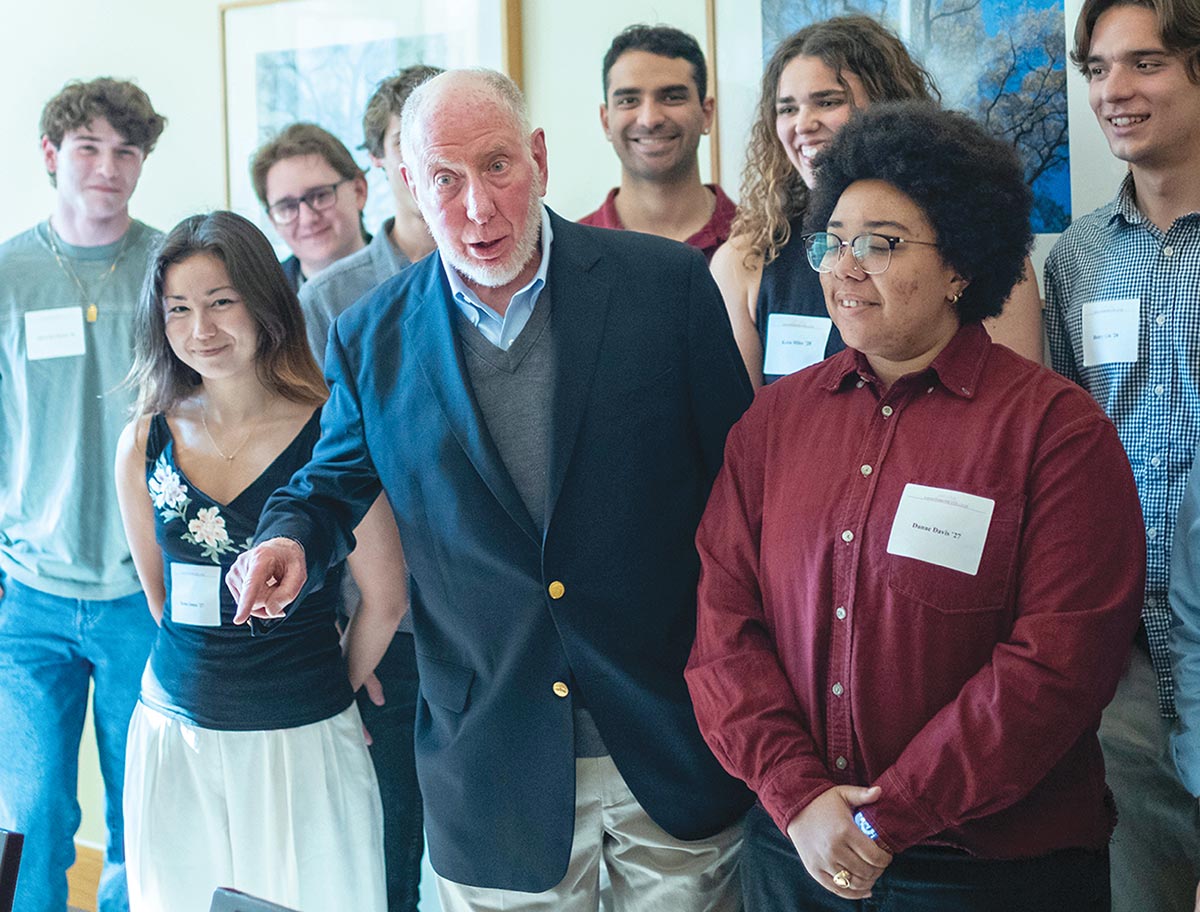 Robert Putnam '63, H'90 points and speaks with smiling students.