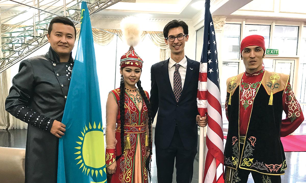 Wren Elhai '08 (second from right) poses with performers at a cultural music and dance competition. He holds a U.S. flag. One of the performers on his left holds the flag of Kazakhstan.