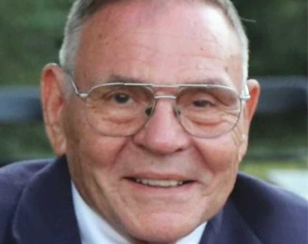 Clarence "Larry" C. Franck Jr. '54 wears glasses and a suit.