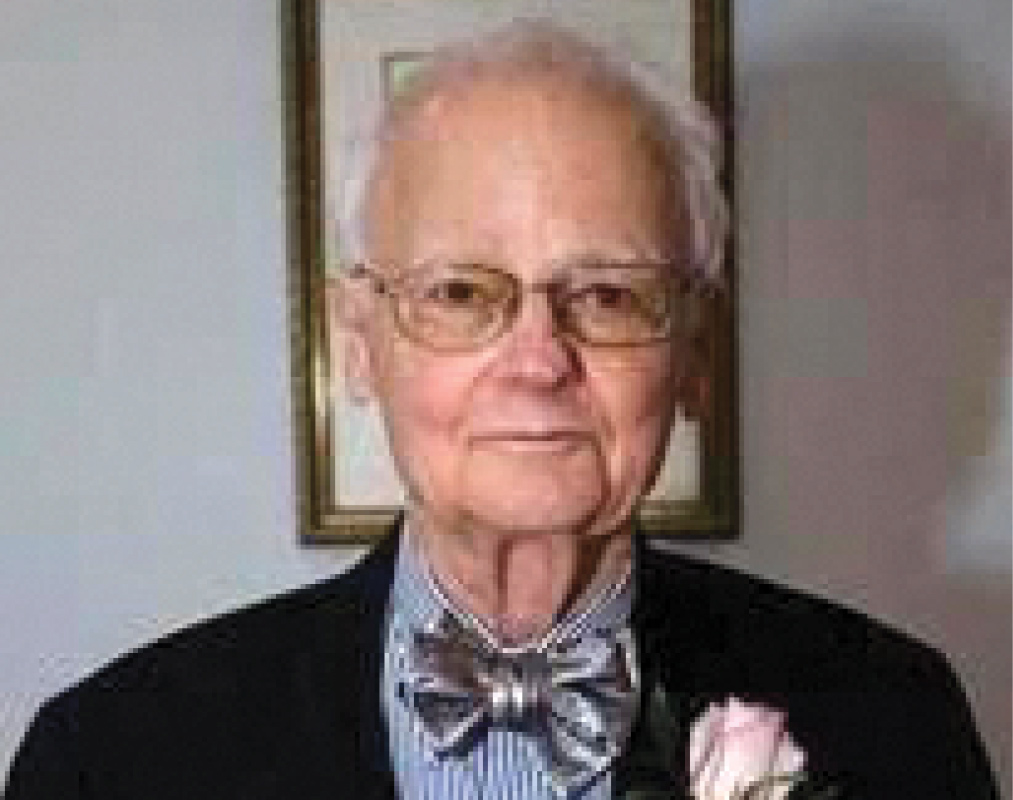 Joseph "Joe" P. Baker '58 in a bowtie with a rose pinned to his lapel.
