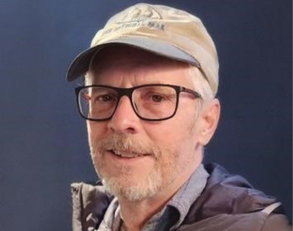 David M. Gillilan '83 wears a baseball cap and glasses