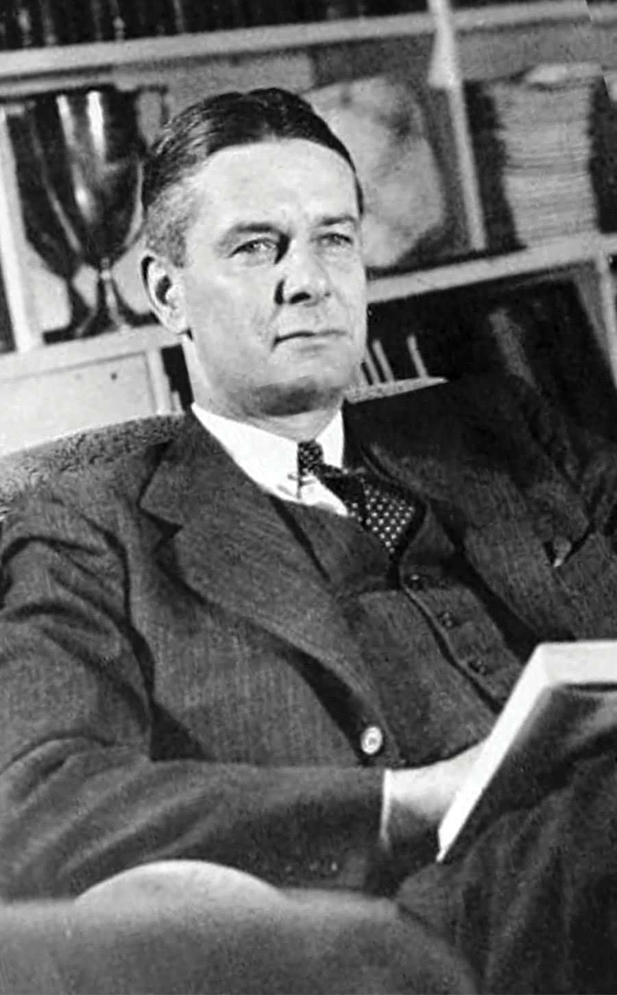 Black and white photo of Swarthmore President Jonathan Nason reclining in a chair with a book.