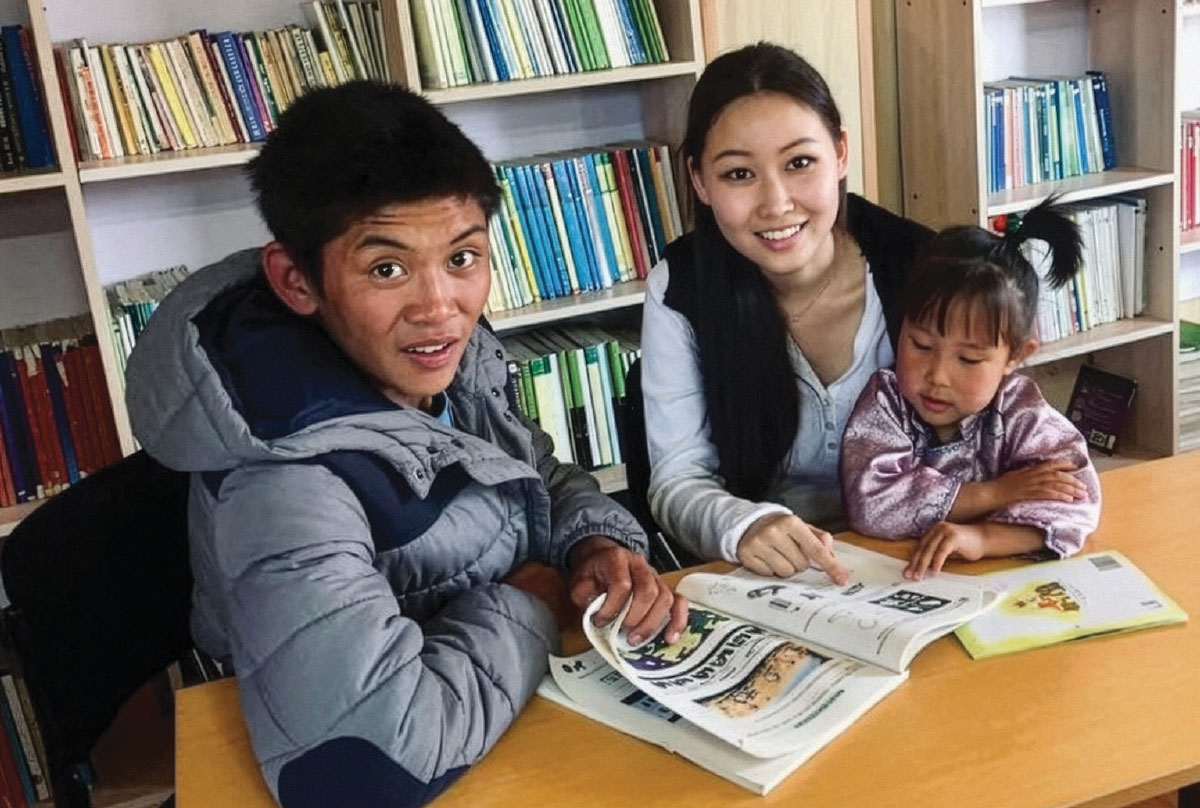 Two parents read to their young child.